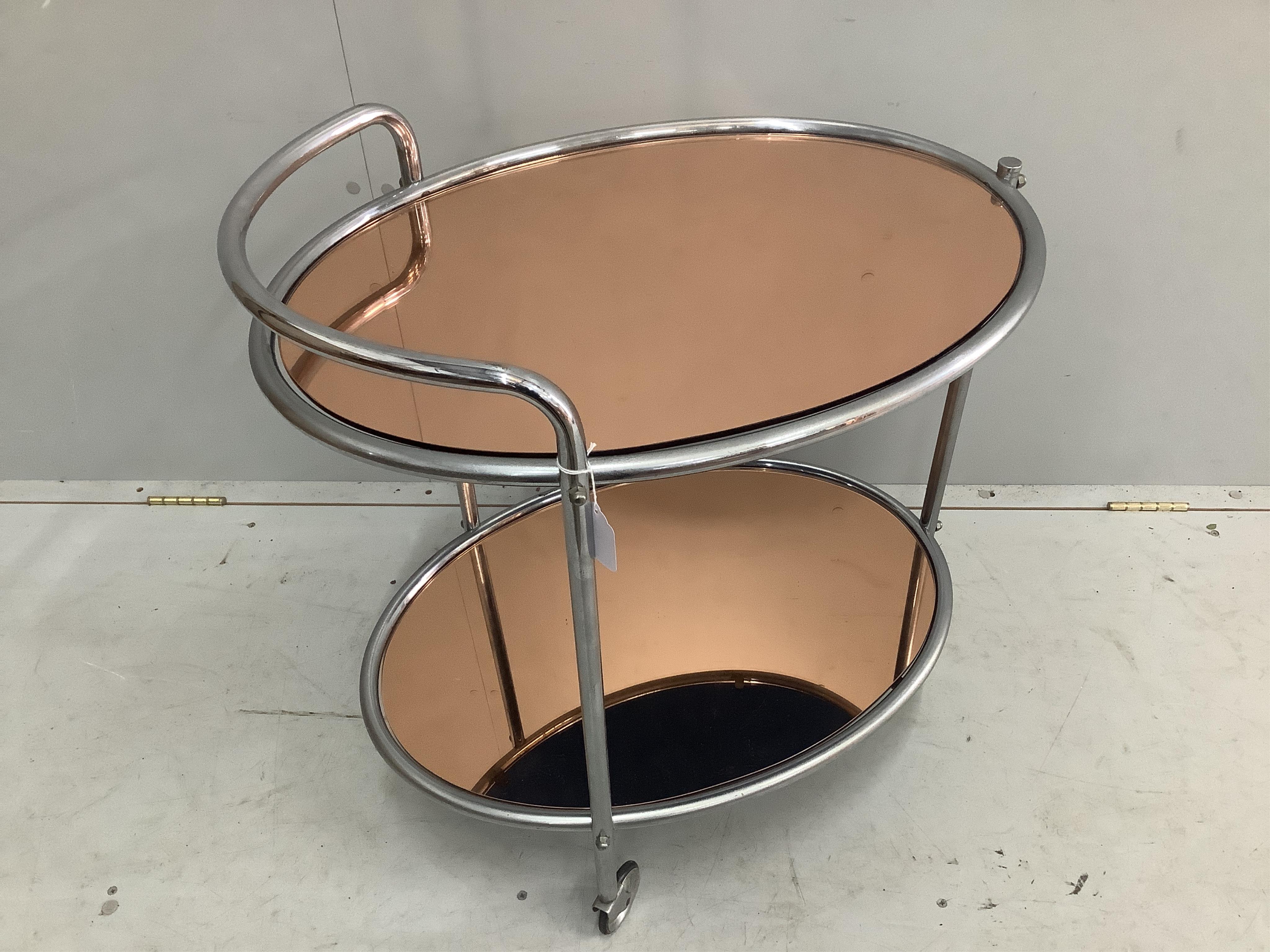 A mid century chrome and peach glass oval two tier drinks trolley, width 66cm, depth 47cm, height 73cm. Condition - fair